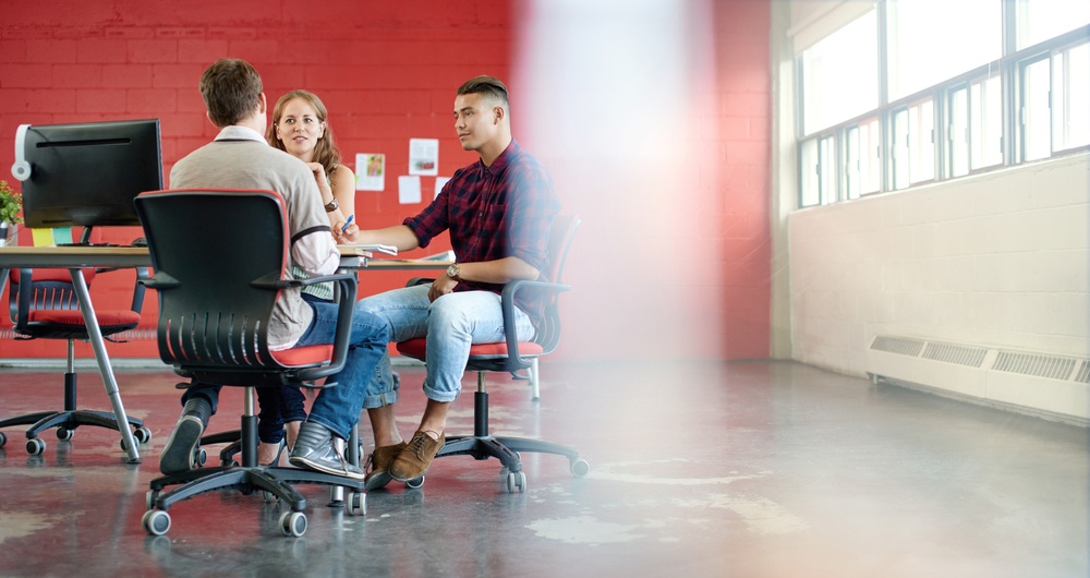 Unposed group of creative business people in an open concept office brainstorming their next project.-2